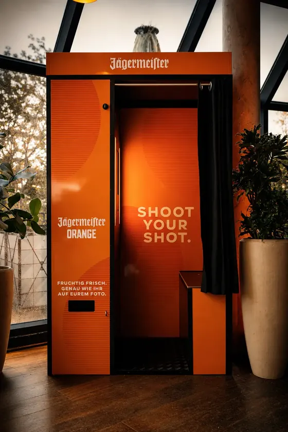 Orange folierter Fotoautomat mit dem Schriftzug Shoot your shot beim Jägermeister Orange Launch Event in Köln.